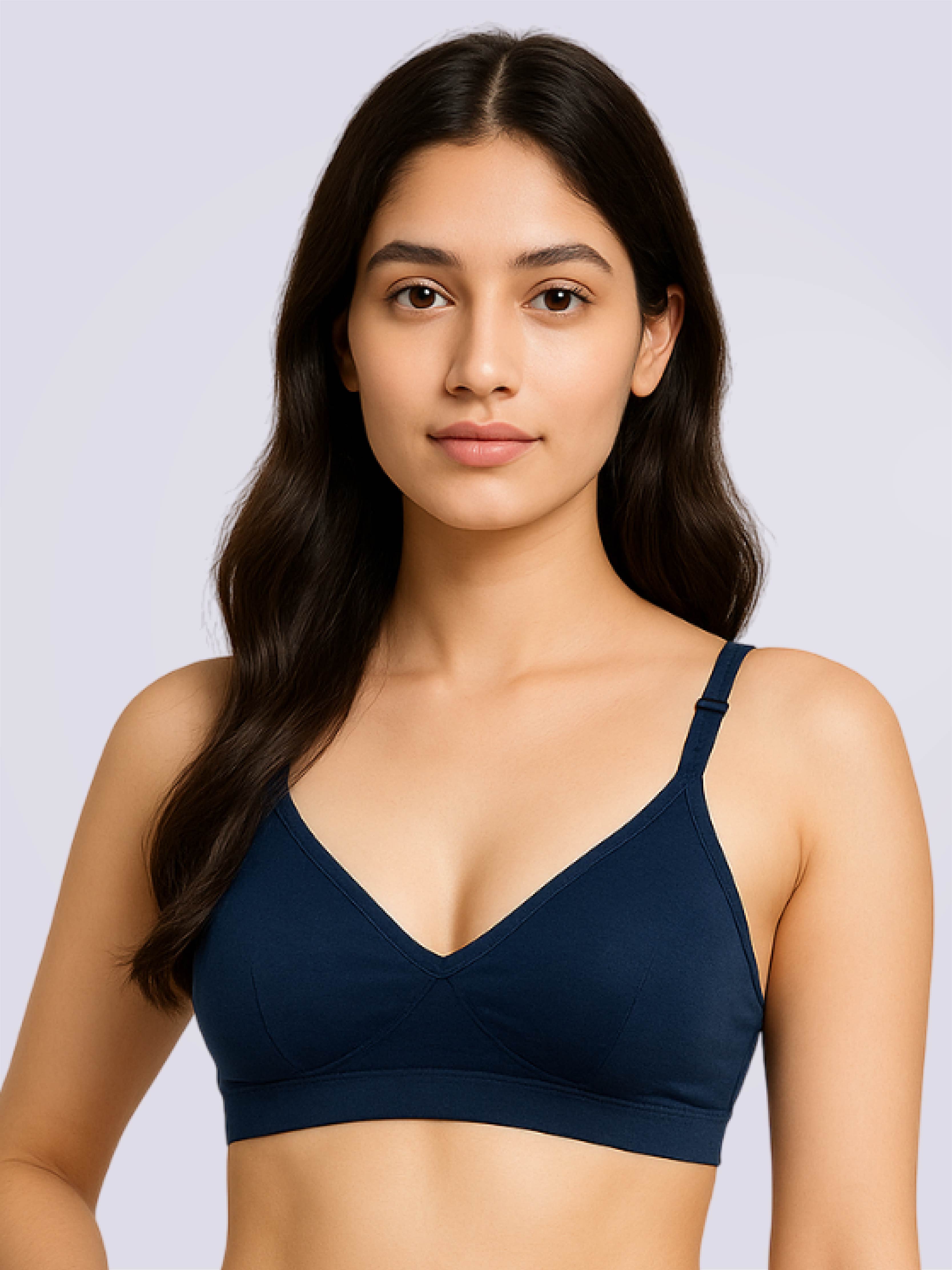 Woman wearing a navy blue bralette against a light gray background